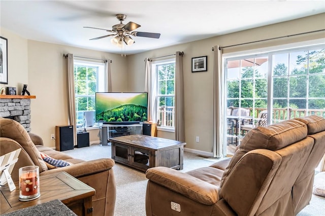 carpeted living room featuring ceiling fan and a fireplace