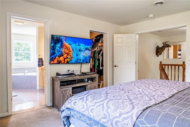 carpeted bedroom with a walk in closet and a closet