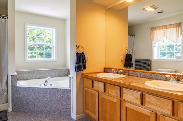 bathroom featuring vanity, toilet, and tiled tub