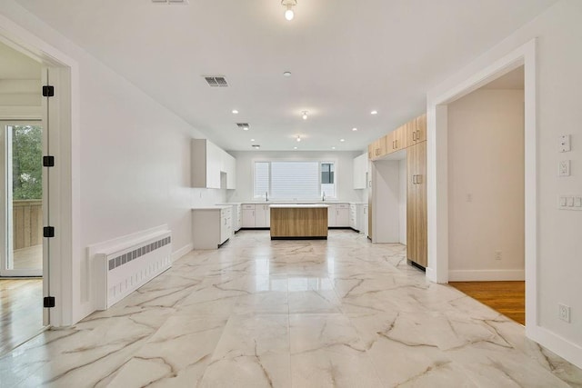 23 Northbrook Rd Unit 202, Spring Valley, NY 10977 - kitchen with radiator, baseboards, a kitchen island, recessed lighting, and light marble finish flooring