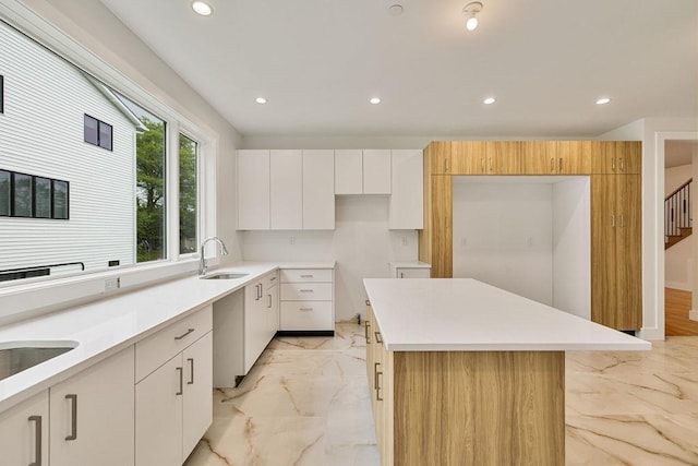 23 Northbrook Rd Unit 202, Spring Valley, NY 10977 - kitchen featuring light marble finish flooring, recessed lighting, a sink, a kitchen island, and white cabinets