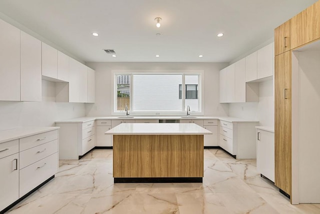 23 Northbrook Rd Unit 202, Spring Valley, NY 10977 - kitchen with a sink, a center island, recessed lighting, light marble finish floors, and white cabinetry