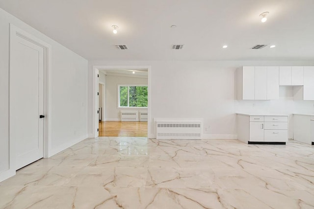23 Northbrook Rd Unit 202, Spring Valley, NY 10977 - unfurnished living room featuring radiator heating unit, light marble finish flooring, baseboards, and recessed lighting