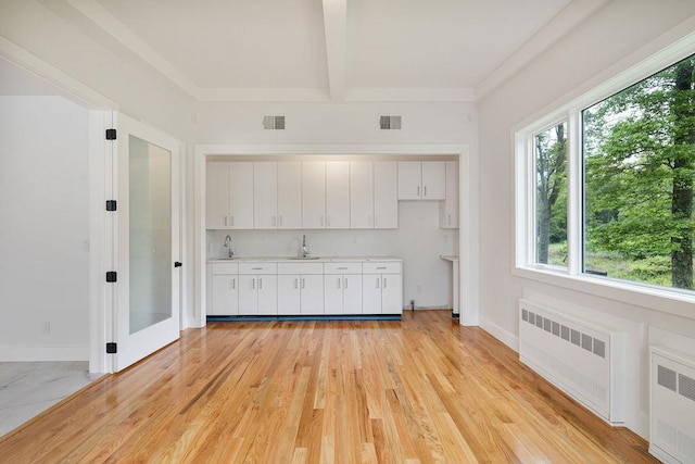 23 Northbrook Rd Unit 202, Spring Valley, NY 10977 - kitchen featuring radiator, light countertops, a sink, white cabinets, and beamed ceiling