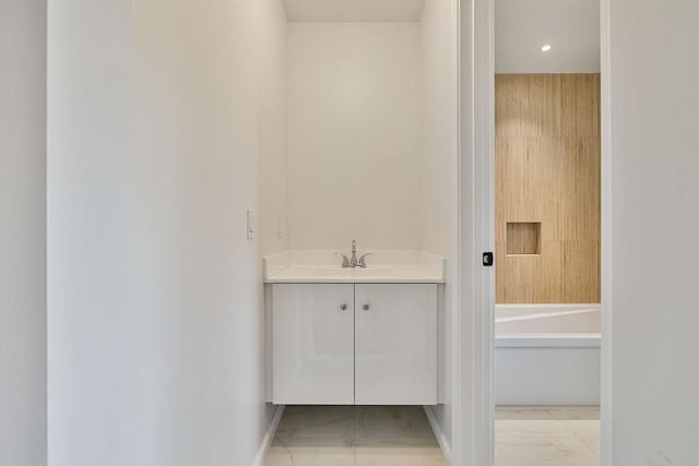 23 Northbrook Rd Unit 202, Spring Valley, NY 10977 - bathroom with marble look tile flooring, vanity, baseboards, and a bathtub