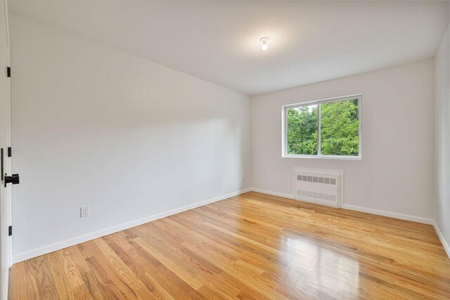 23 Northbrook Rd Unit 202, Spring Valley, NY 10977 - spare room featuring radiator heating unit, baseboards, and light wood finished floors