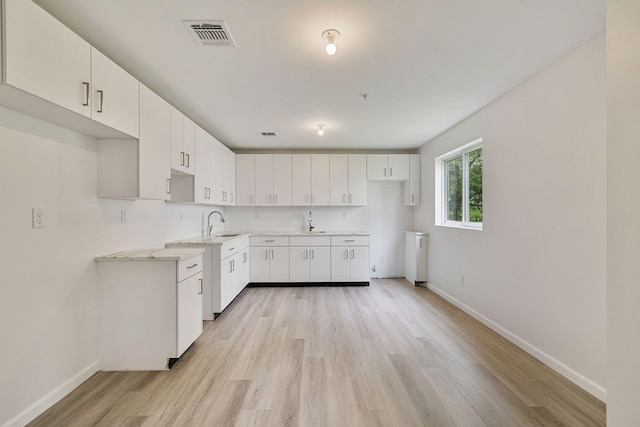 23 Northbrook Rd Unit 202, Spring Valley, NY 10977 - kitchen featuring baseboards, a sink, light wood-type flooring, and white cabinets