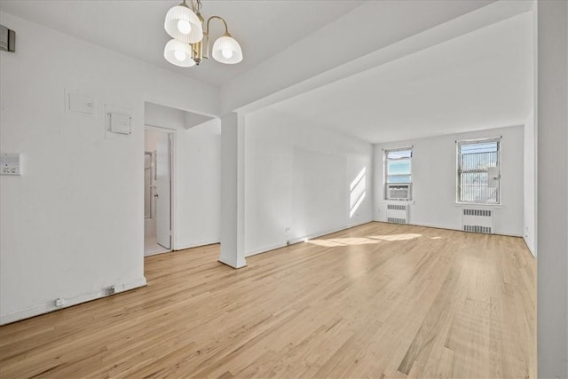 interior space with a notable chandelier, cooling unit, light wood-type flooring, and radiator