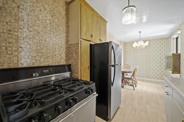 kitchen featuring decorative light fixtures, light hardwood / wood-style flooring, light brown cabinetry, a notable chandelier, and stainless steel appliances