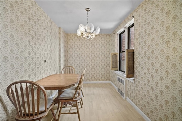 dining space with radiator heating unit, light wood-type flooring, and a notable chandelier
