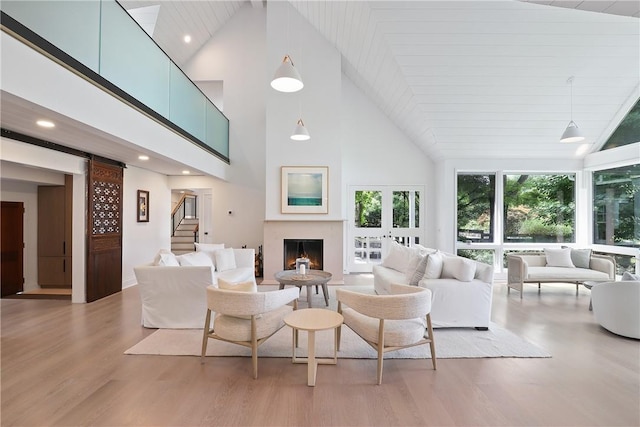 living room with light wood-type flooring and high vaulted ceiling