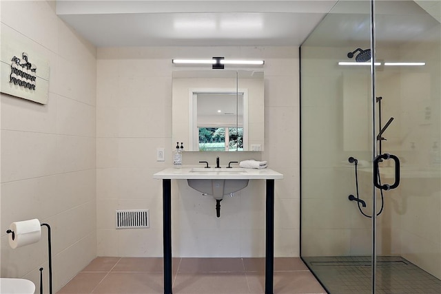 bathroom featuring tile patterned flooring, a shower with shower door, and sink