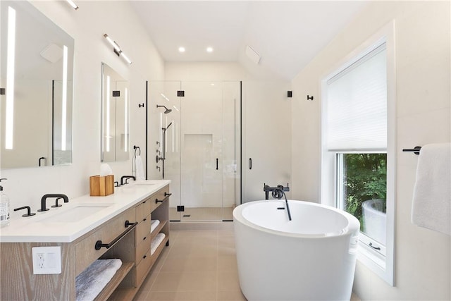 bathroom featuring tile patterned flooring, vanity, shower with separate bathtub, and vaulted ceiling