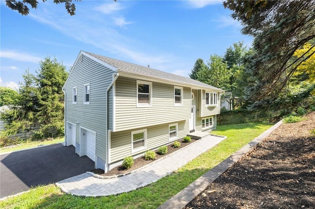 split foyer home with a front lawn and a garage