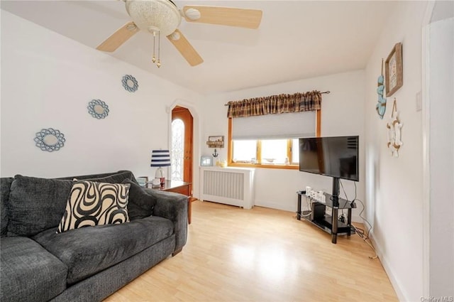 living room featuring radiator, light hardwood / wood-style floors, and ceiling fan