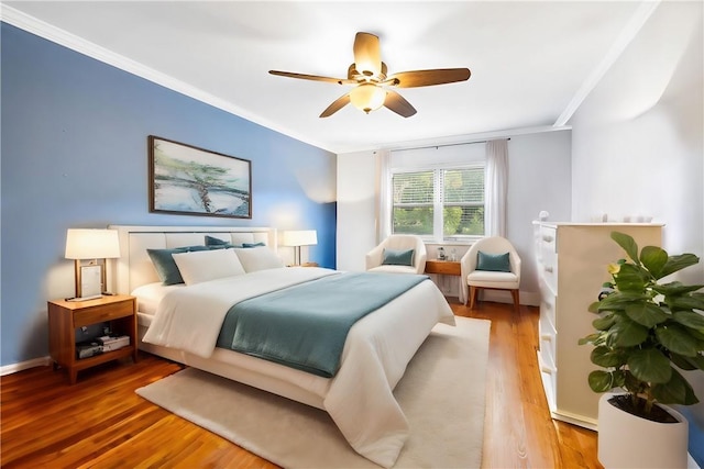 bedroom with hardwood / wood-style flooring, ceiling fan, and crown molding