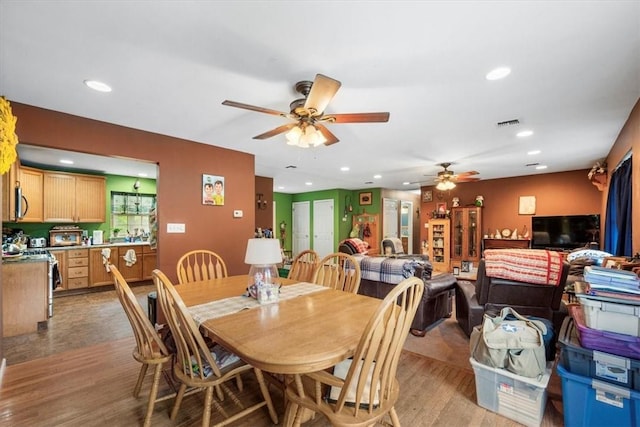 dining space with light wood-type flooring and ceiling fan