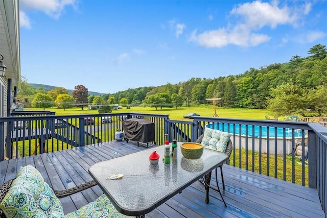 deck featuring a lawn and a grill