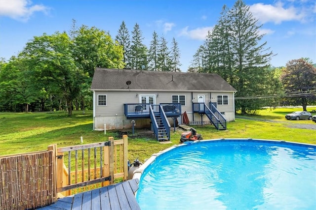 view of swimming pool featuring a lawn and a wooden deck