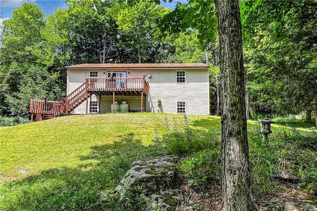 rear view of house featuring a deck and a lawn