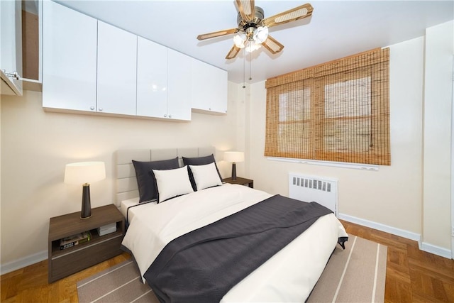 bedroom featuring ceiling fan, dark parquet flooring, and radiator heating unit