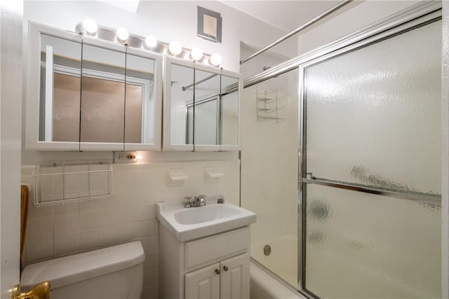 full bathroom featuring backsplash, vanity, tile walls, enclosed tub / shower combo, and toilet