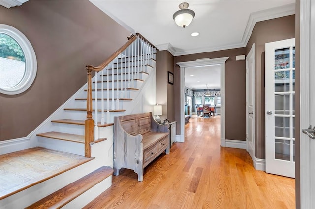 entrance foyer featuring a chandelier, light wood-type flooring, and ornamental molding