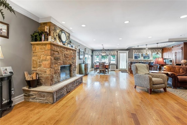 living room with a fireplace, light hardwood / wood-style floors, and ornamental molding