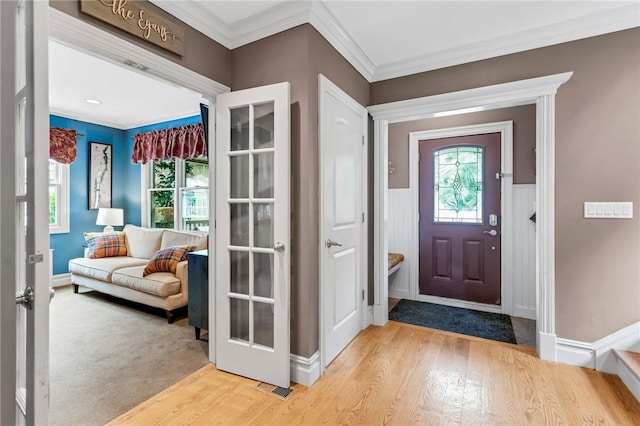 entrance foyer with light wood-type flooring and crown molding