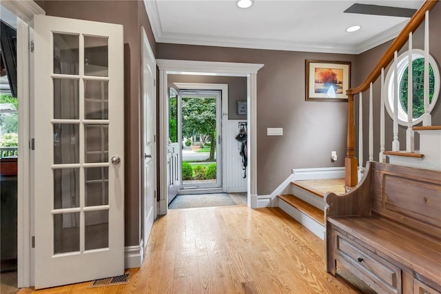 entryway with light wood-type flooring and crown molding