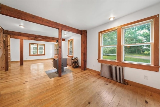 empty room with radiator heating unit and light hardwood / wood-style flooring