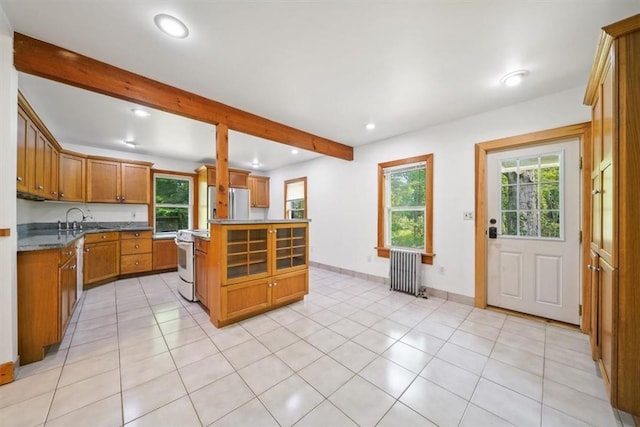 kitchen with plenty of natural light, stainless steel fridge, white range oven, and radiator heating unit