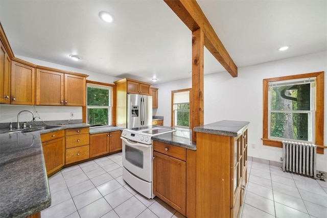 kitchen featuring white range oven, stainless steel fridge with ice dispenser, beam ceiling, radiator heating unit, and a kitchen island