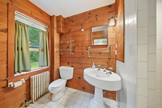 bathroom with wooden walls, a healthy amount of sunlight, and radiator