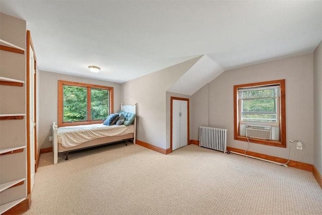 unfurnished bedroom featuring cooling unit, radiator heating unit, light carpet, and multiple windows