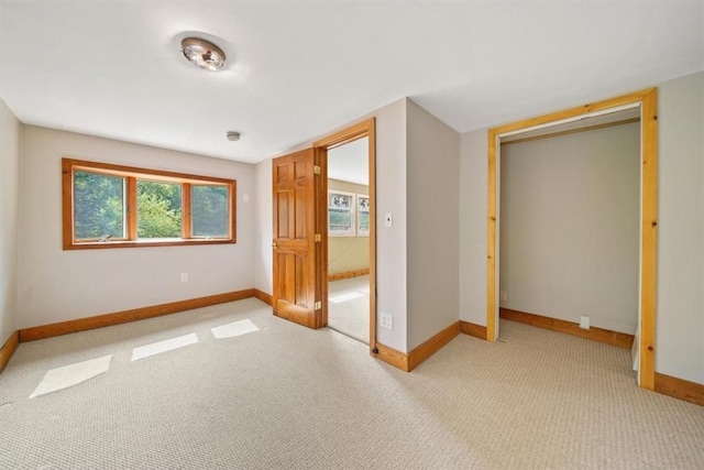 unfurnished bedroom featuring light carpet and a closet