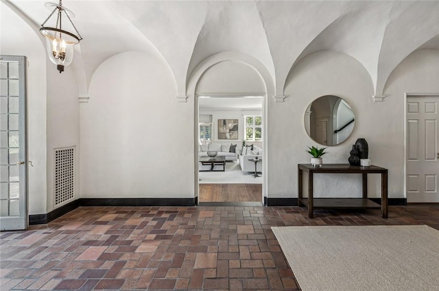 entryway with lofted ceiling and a notable chandelier