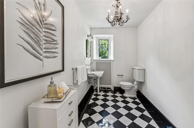 bathroom with a notable chandelier and toilet