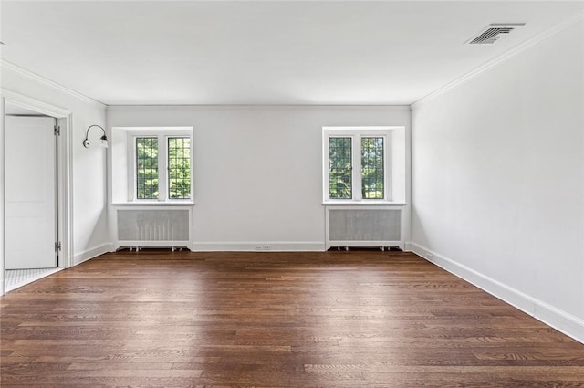 empty room featuring dark hardwood / wood-style flooring, radiator, and crown molding