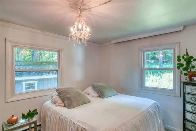 bedroom with a baseboard radiator, crown molding, and a notable chandelier