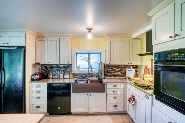 kitchen featuring backsplash, sink, light tile patterned floors, and black appliances