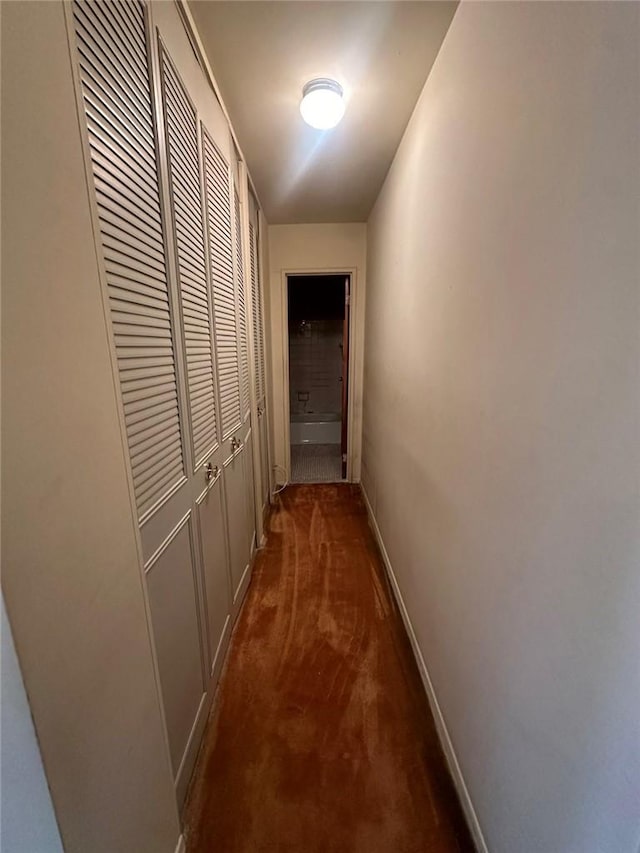 corridor featuring dark colored carpet