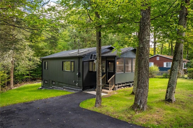 view of front of home featuring a front yard and a sunroom