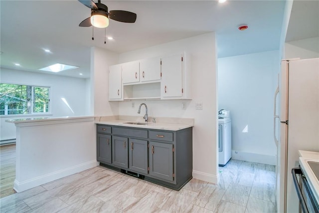 kitchen featuring a skylight, white cabinetry, sink, gray cabinetry, and washer / clothes dryer