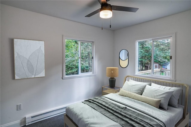 bedroom featuring a baseboard radiator, multiple windows, and ceiling fan