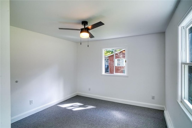 empty room featuring carpet flooring, ceiling fan, and a baseboard heating unit