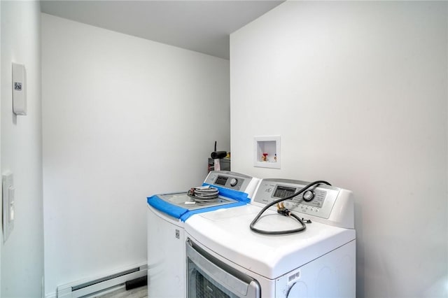 clothes washing area featuring baseboard heating and washing machine and clothes dryer