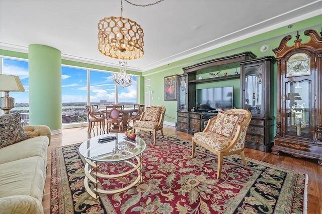 living room with ornamental molding, a healthy amount of sunlight, a notable chandelier, and hardwood / wood-style flooring