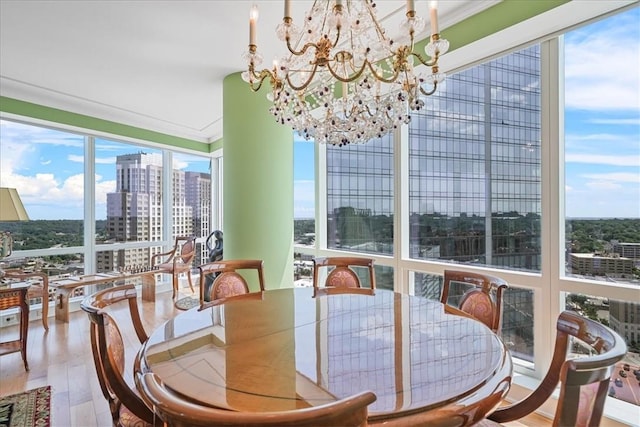 dining space featuring hardwood / wood-style floors, ornamental molding, and an inviting chandelier