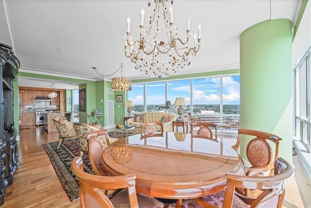 dining room with crown molding and light hardwood / wood-style flooring